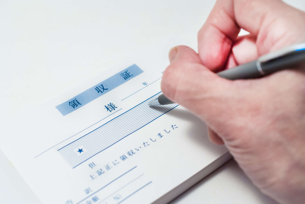 領収証をボールペンで記入している画像