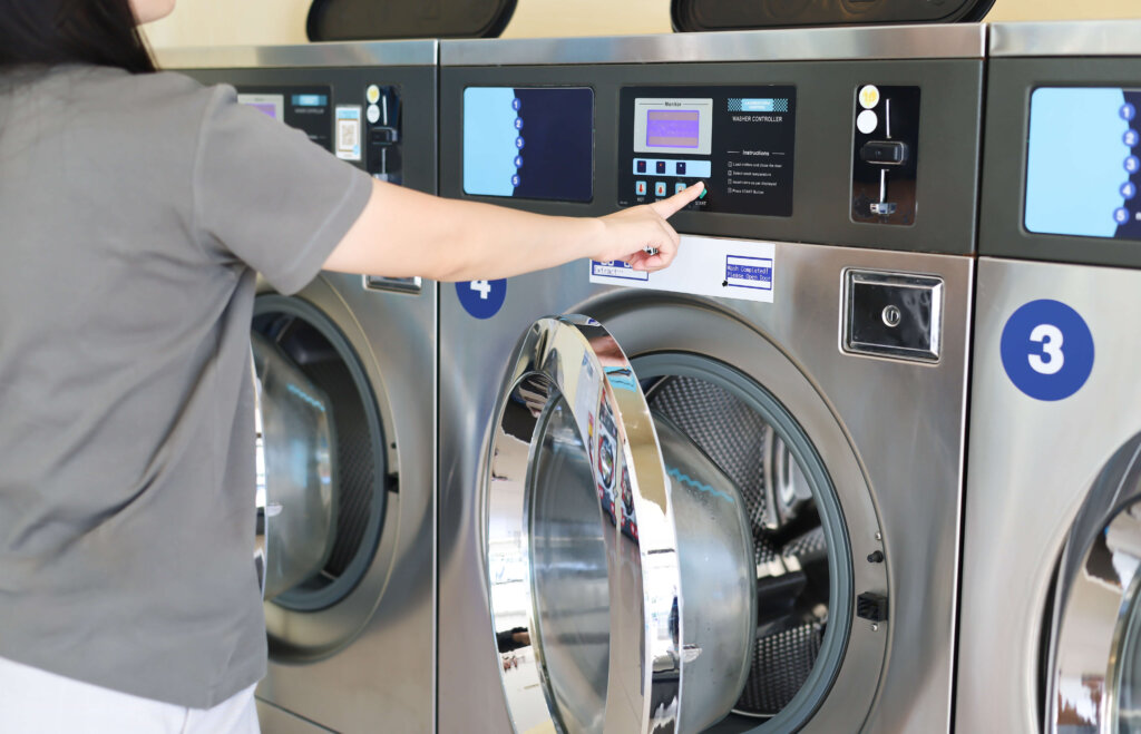 洗濯機のボタンを押している女性