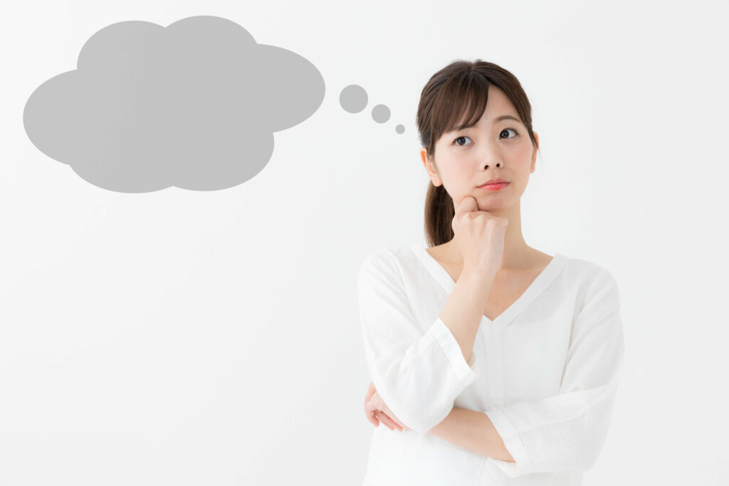 首をかしげて考えている女性